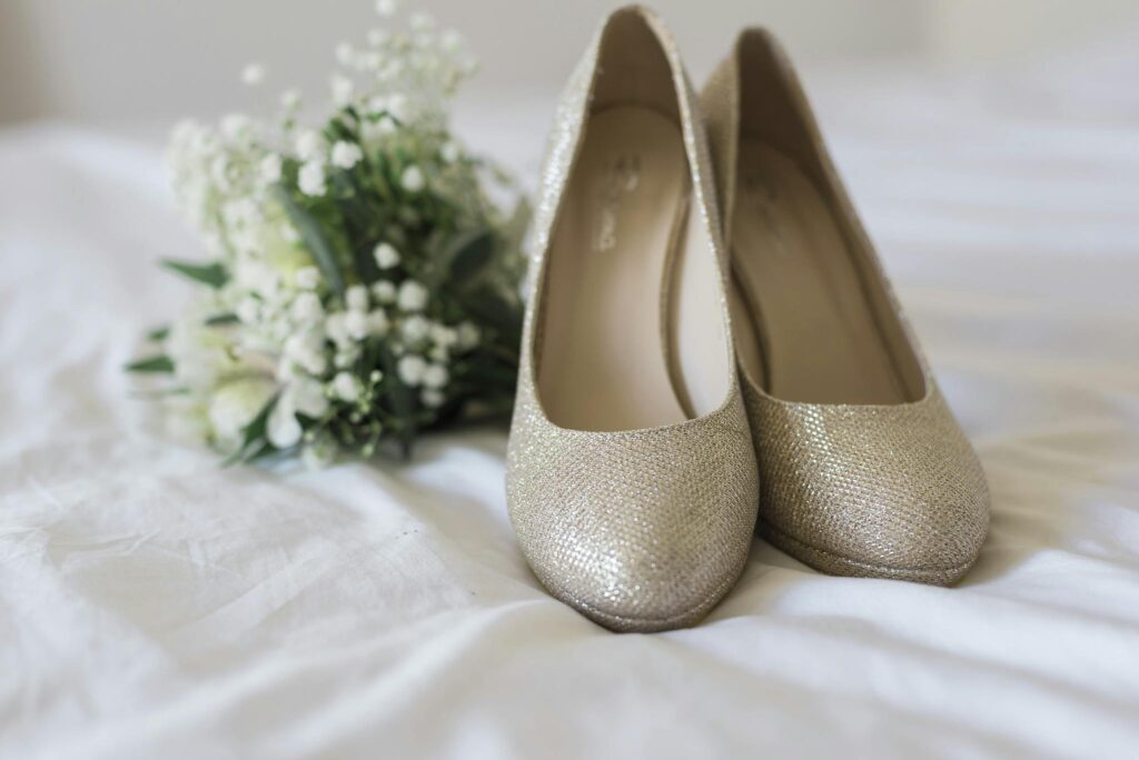 Beautiful golden bridal shoes paired with a delicate white bouquet, perfect for wedding style inspiration.