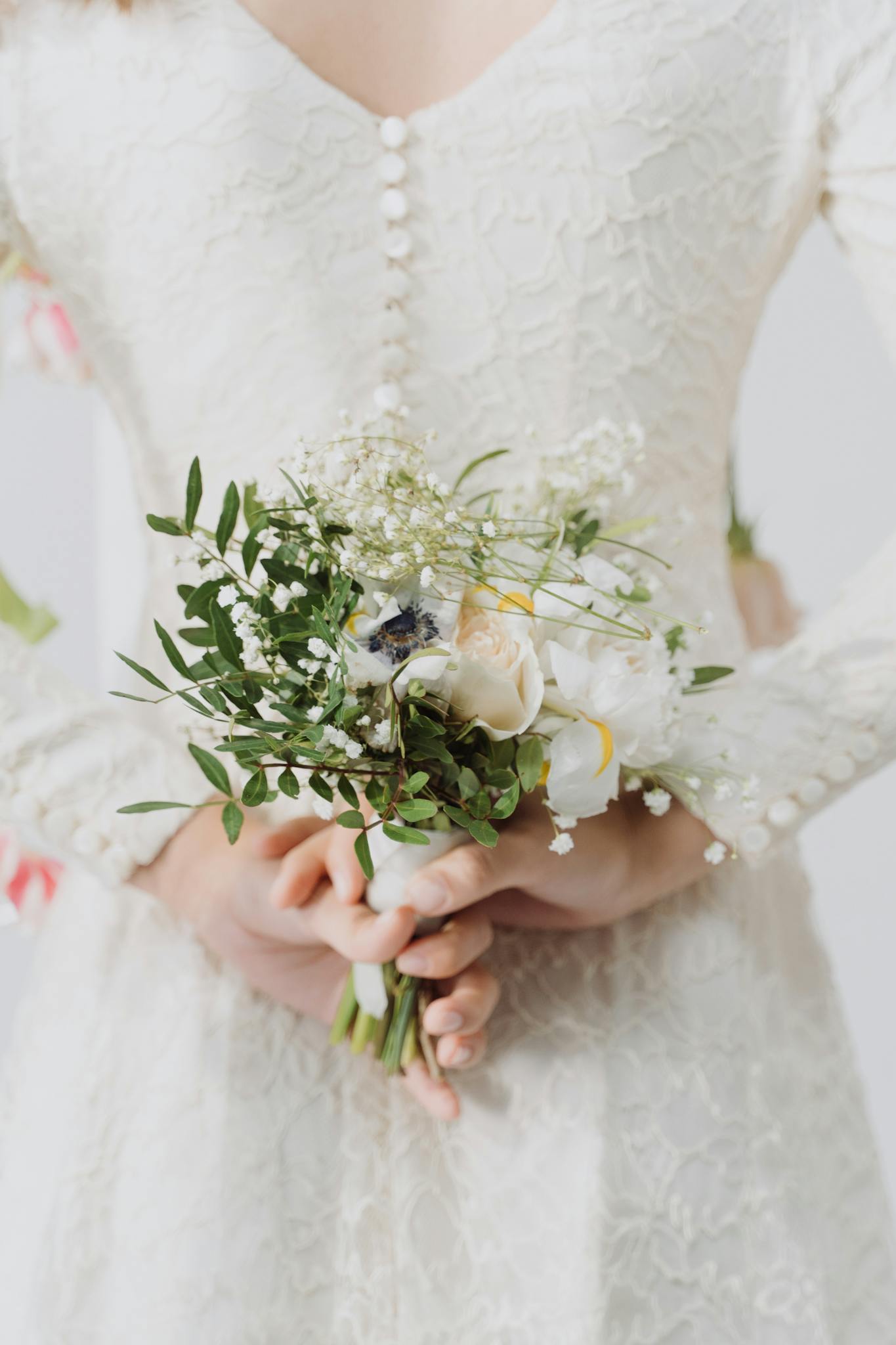 Bride in lace dress holding a floral bouquet, symbolizing elegance and purity on her wedding day.