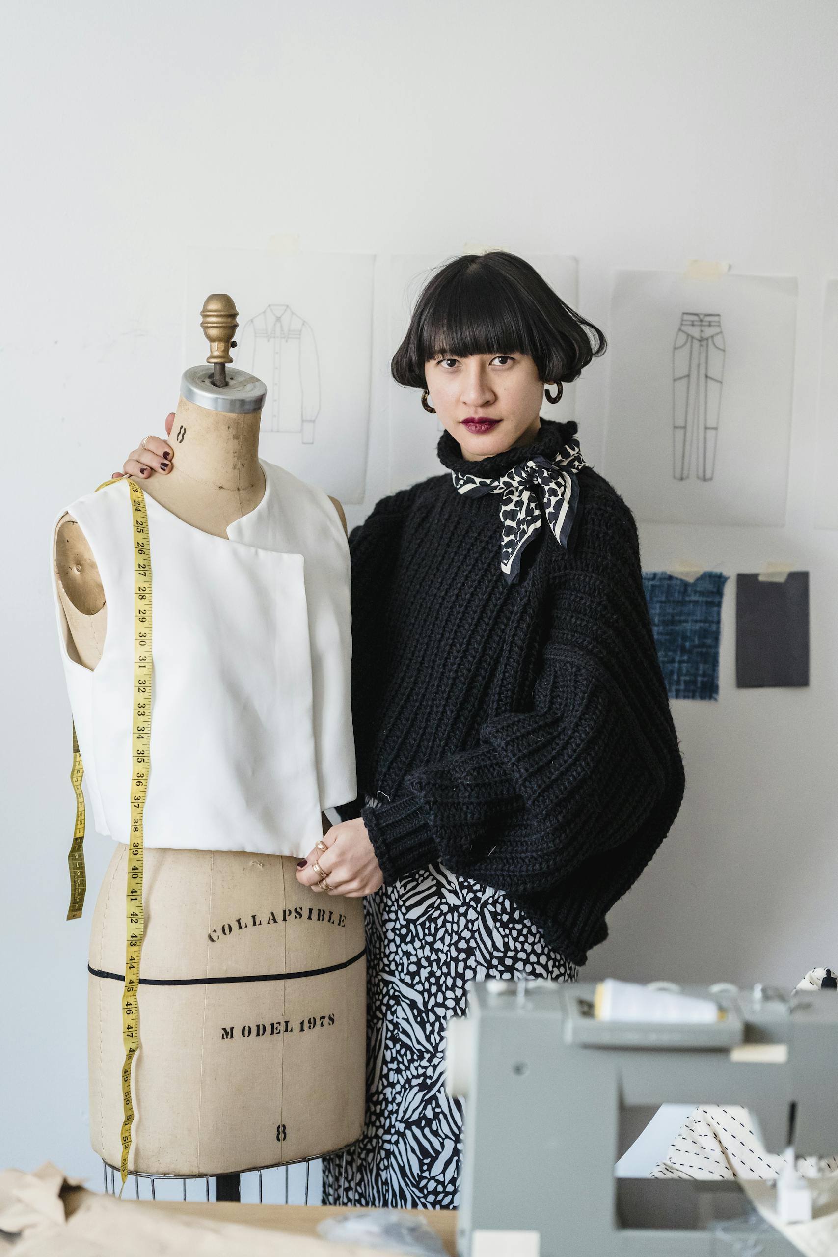 A young designer in a studio working with a mannequin, showcasing creativity.