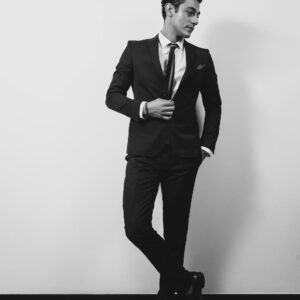 Photo by W R Black and white portrait of a sophisticated man in formal attire striking a confident pose.