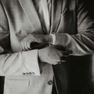 Man adjusting blazer in a stylish suit, exuding elegance in Leipzig.