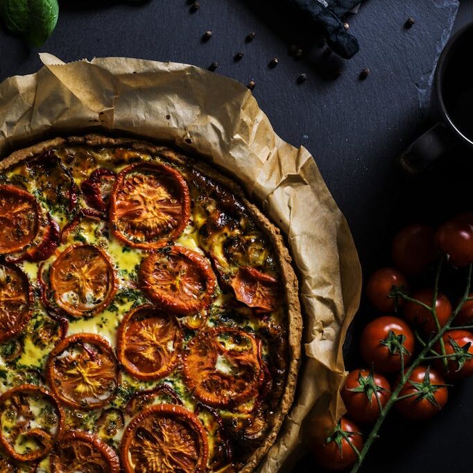 Pizza With Tomatoes on Black Surface