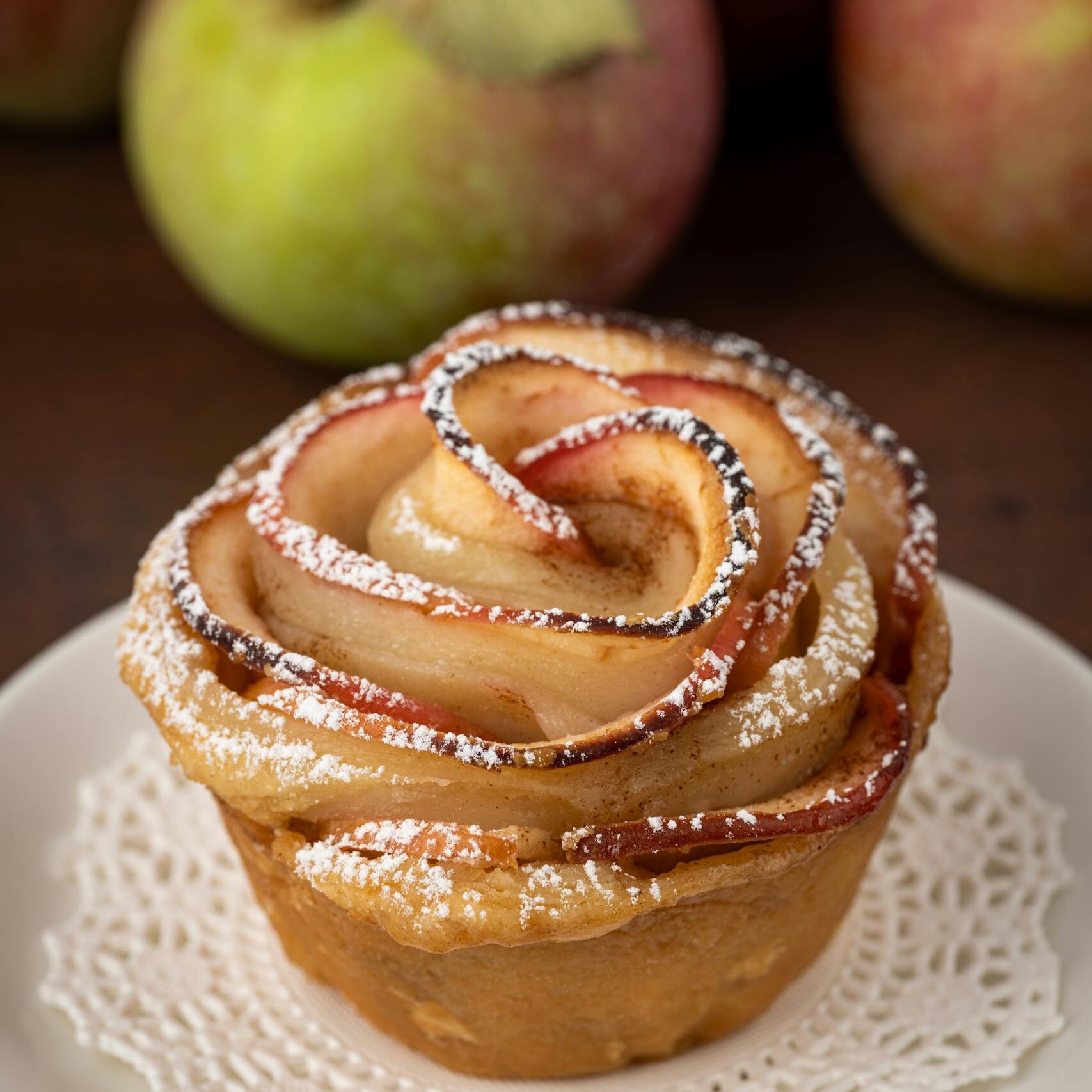 A beautifully crafted apple rose tart on a ceramic plate, perfect for dessert delights.