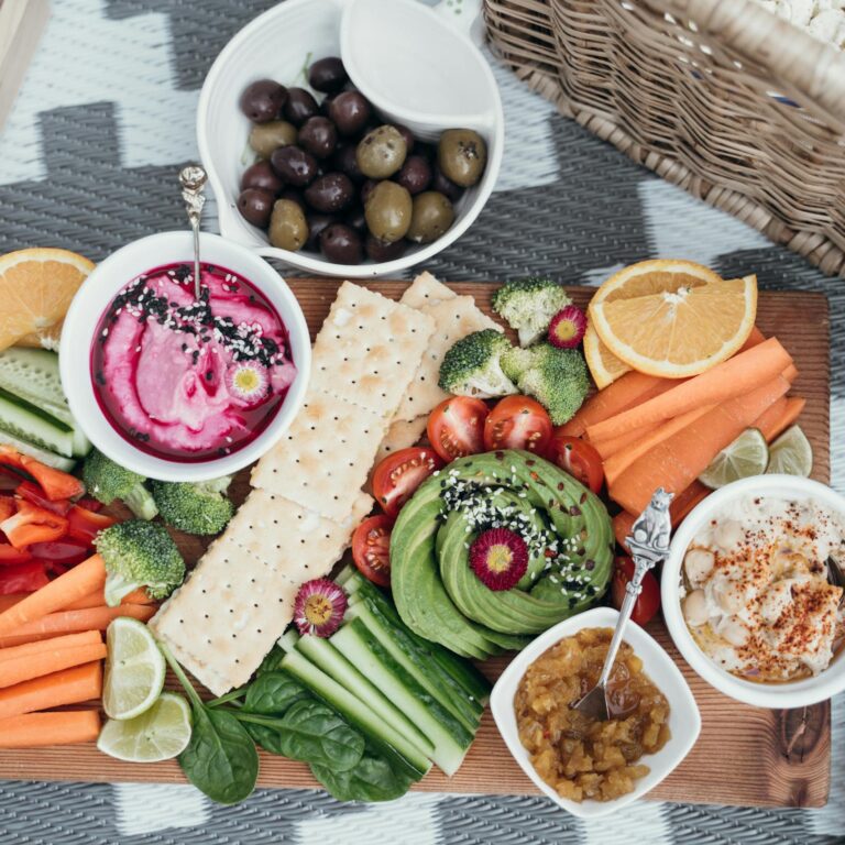 Colorful vegan platter featuring fresh vegetables, dips, and olives. Perfect for a healthy snack or party.