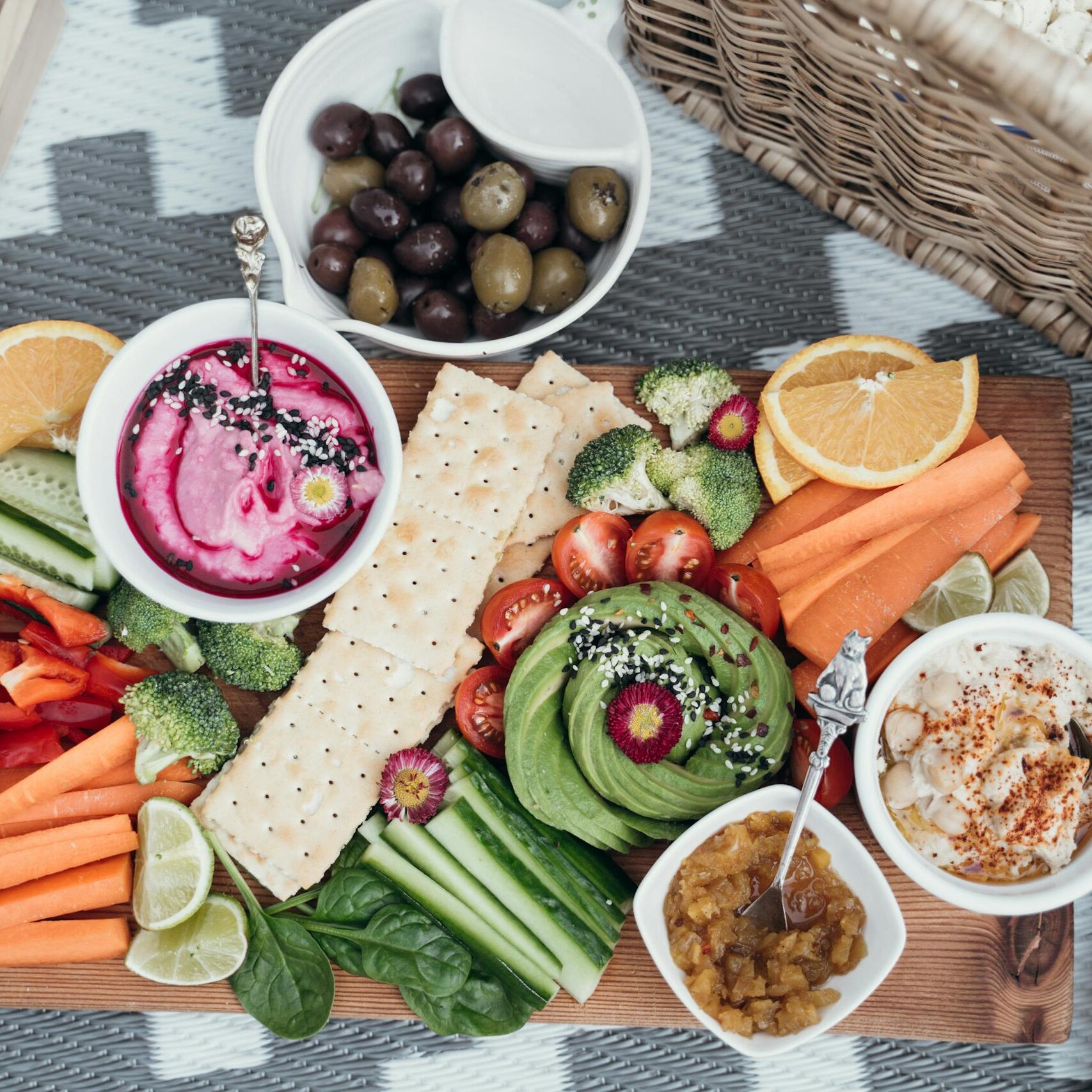 Colorful vegan platter featuring fresh vegetables, dips, and olives. Perfect for a healthy snack or party.