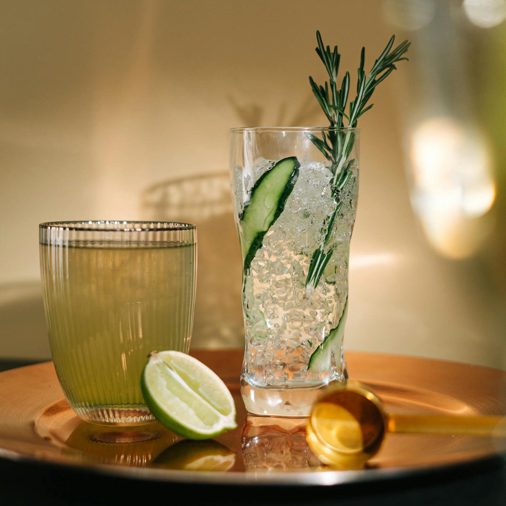 Elegant cocktails on a tray with lime and rosemary garnish, perfect for an upscale gathering.