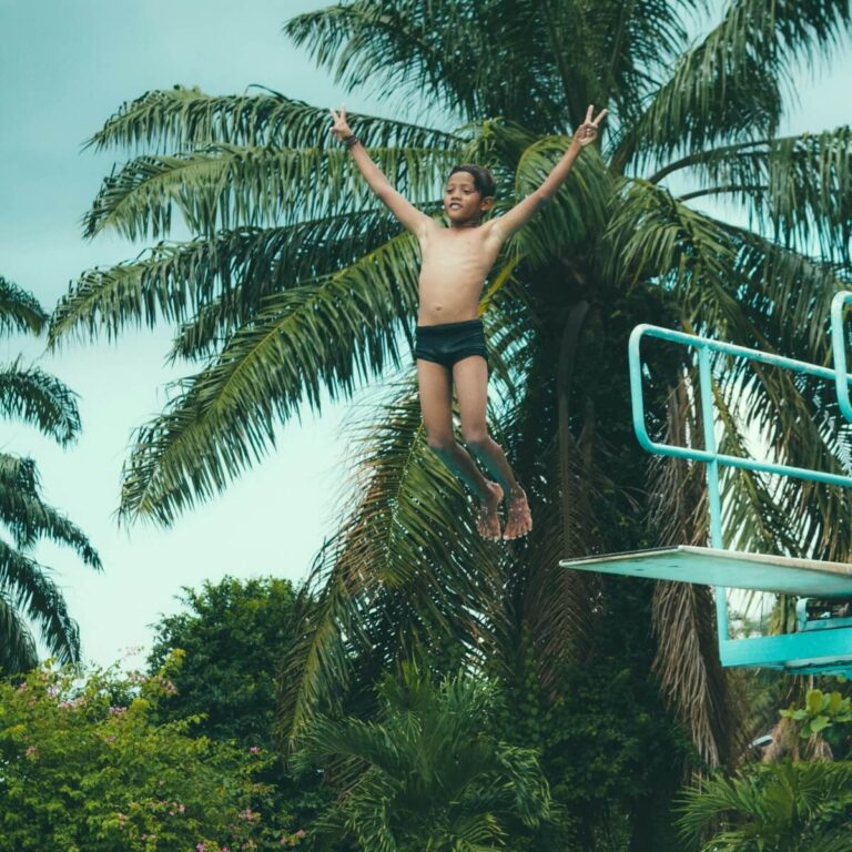 boy jumping of a swimming board