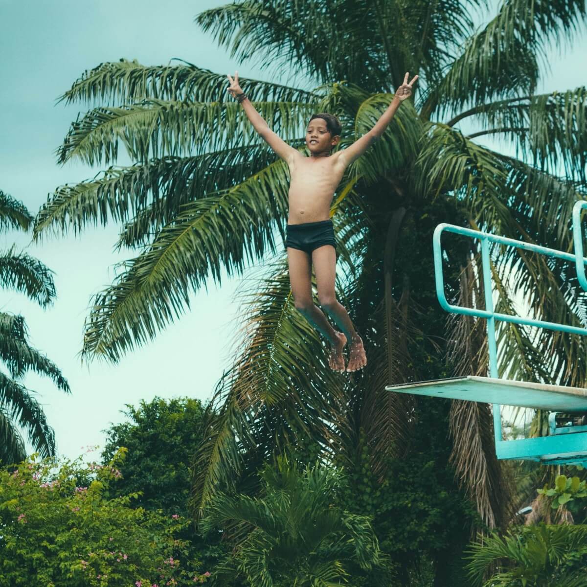 boy jumping of a swimming board