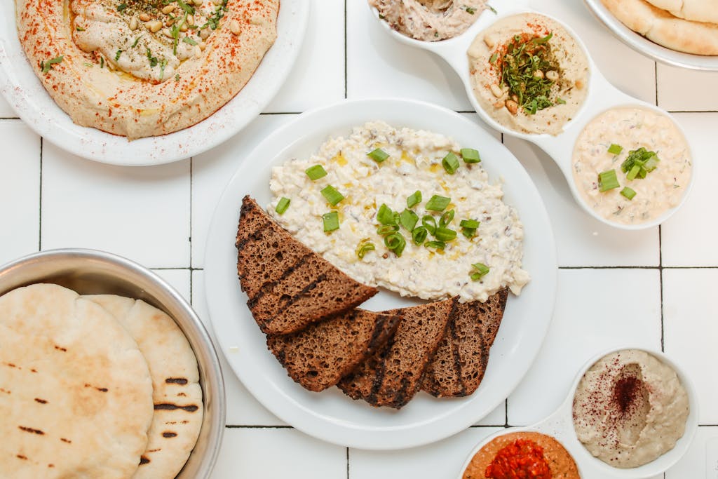 Top view of Mediterranean dips with rye bread, showcasing variety and delicious presentation.