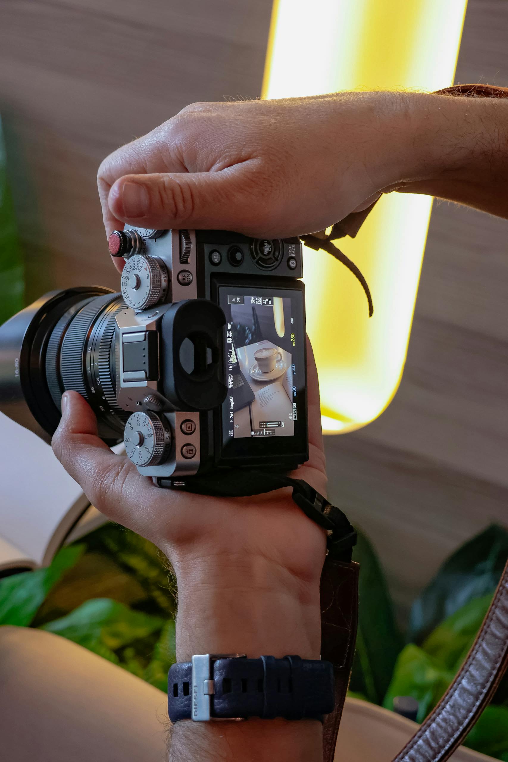 Close-up of a photographer capturing coffee cup on camera screen. Photo by 𝐄𝐛𝐚𝐡𝐢𝐫