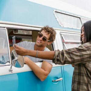 Photo by RDNE Stock project Happy couple on a road trip in a vintage blue camper van, embracing the van life spirit.