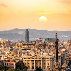 A stunning sunset view of the Barcelona skyline showcasing iconic landmarks and a warm, golden hour glow.