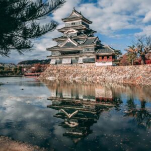 Reflection of Matsumoto Castle in Japan during autumn, surrounded by a serene lake.