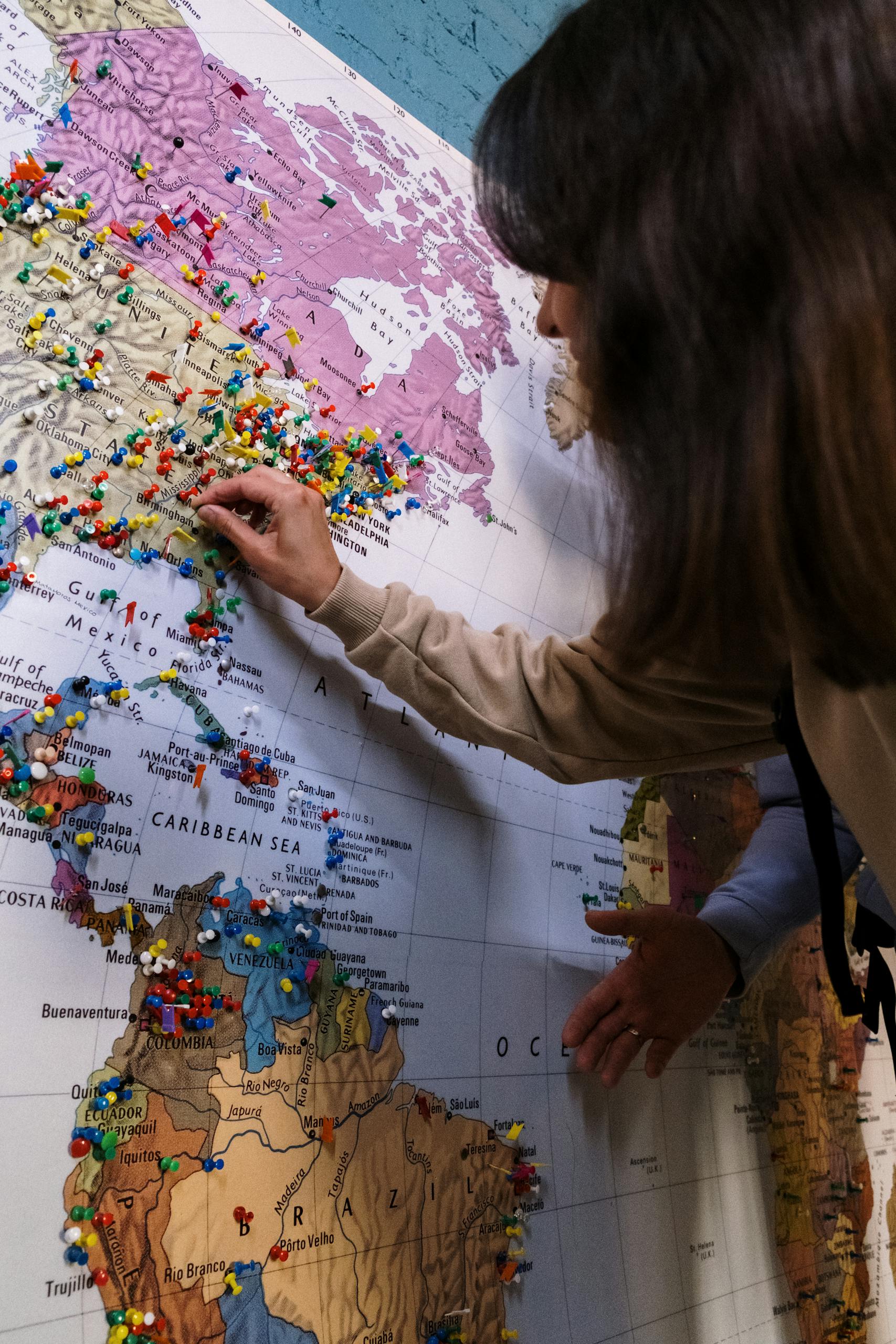 Travelers pin destinations on a world map, symbolizing global exploration.
