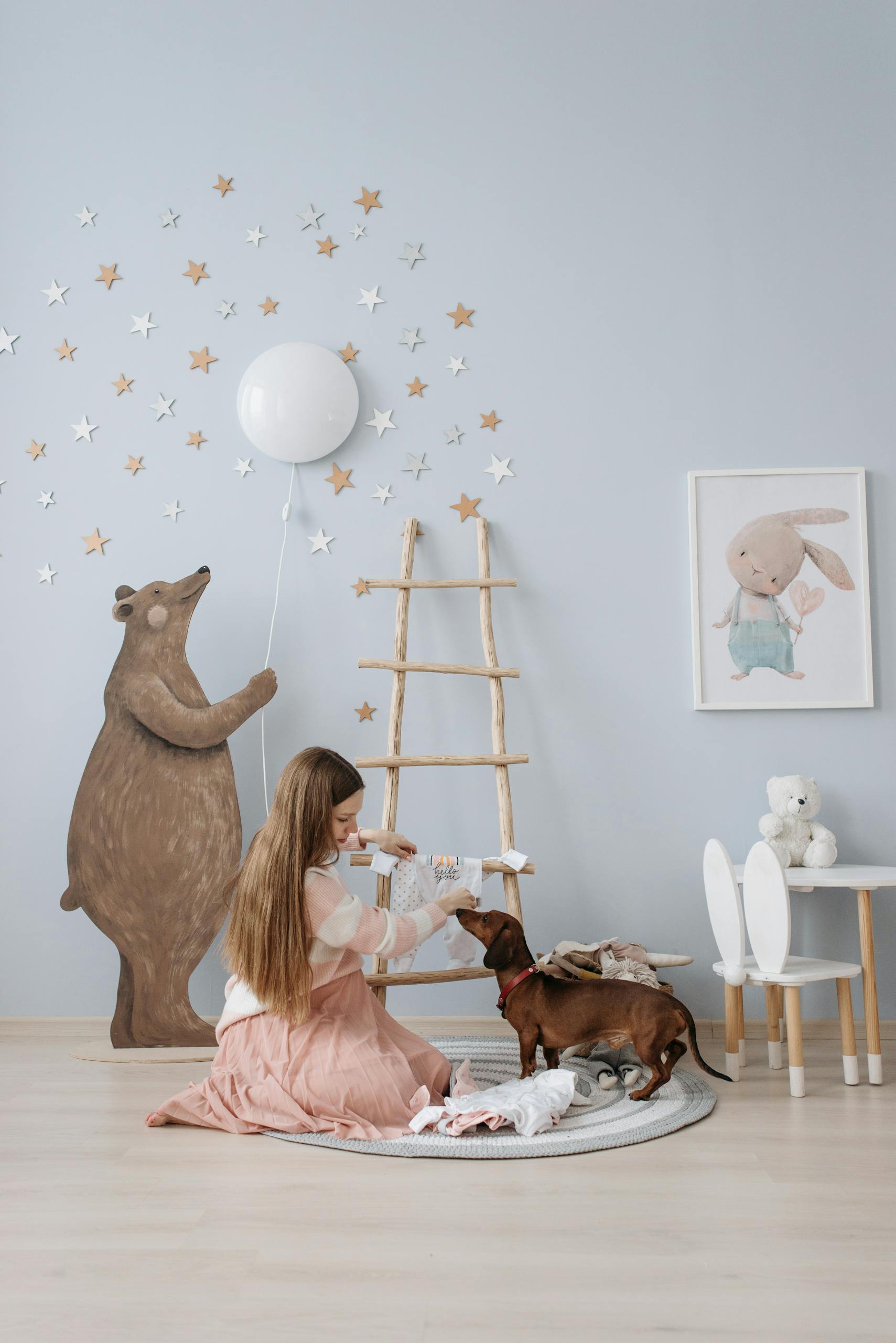 Pregnant woman in a stylish nursery room with a dog and balloon, creating a warm and loving atmosphere.