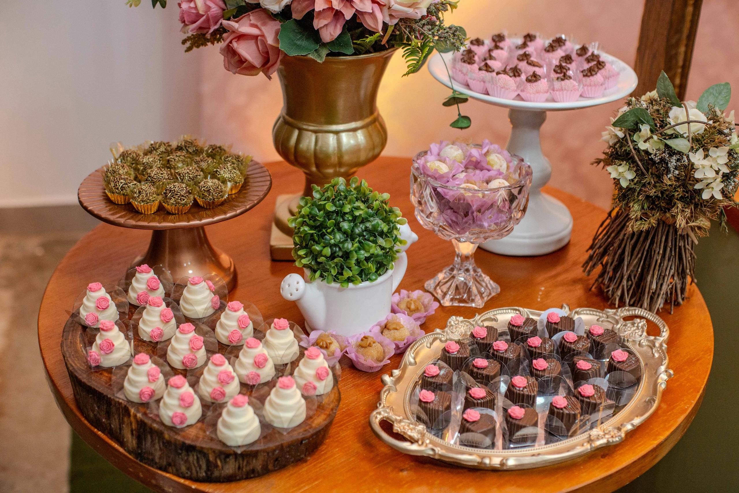 A beautifully arranged dessert table with assorted sweets and floral decorations, perfect for celebrations.