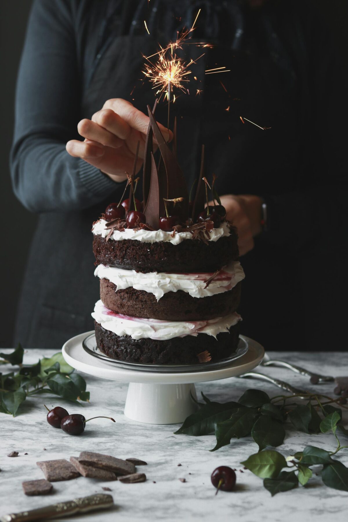 A rich chocolate cake decorated with a sparkler, perfect for celebrations and special occasions.