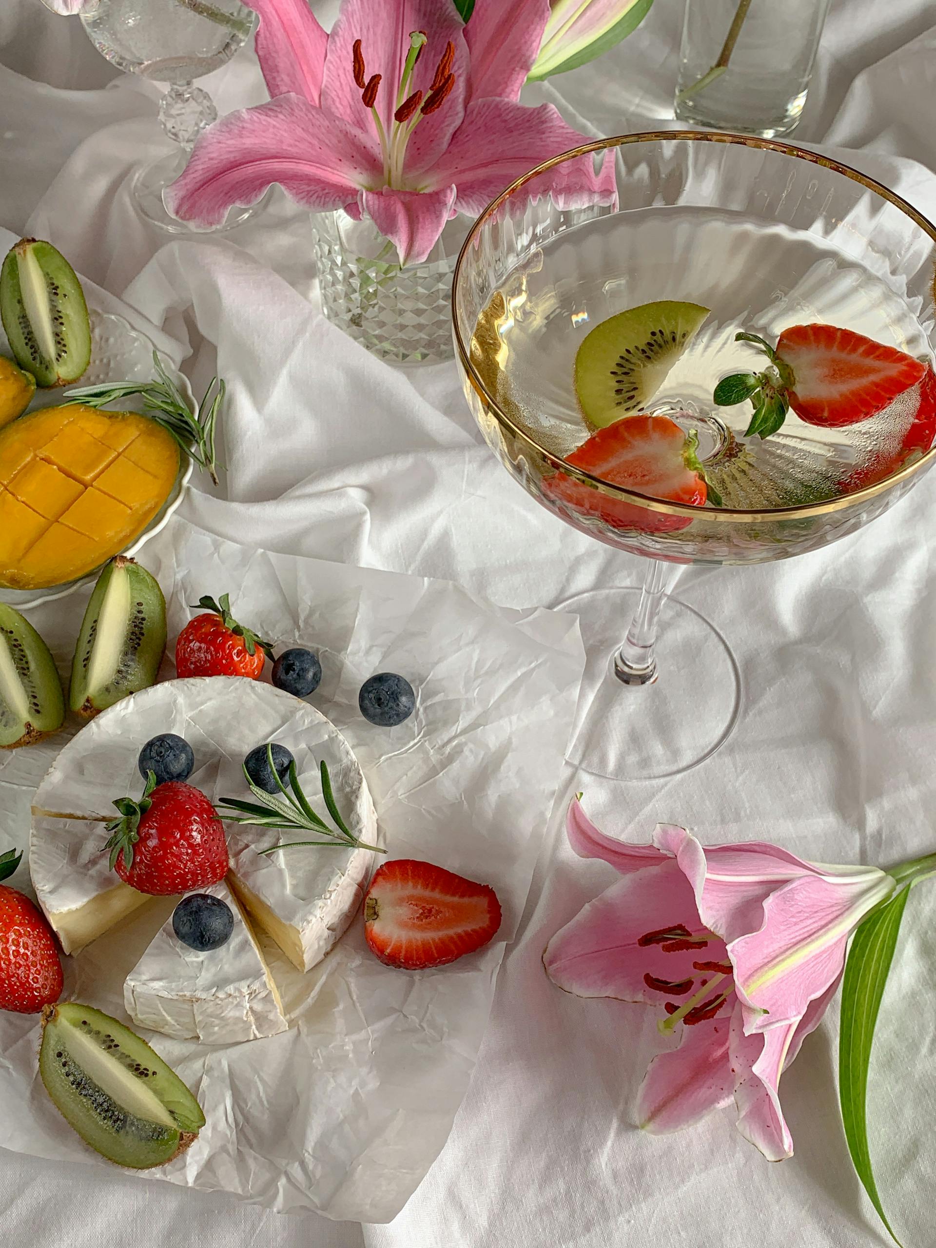 Cheese and fruit platter with wine, beautifully arranged with lilies for an elegant touch.