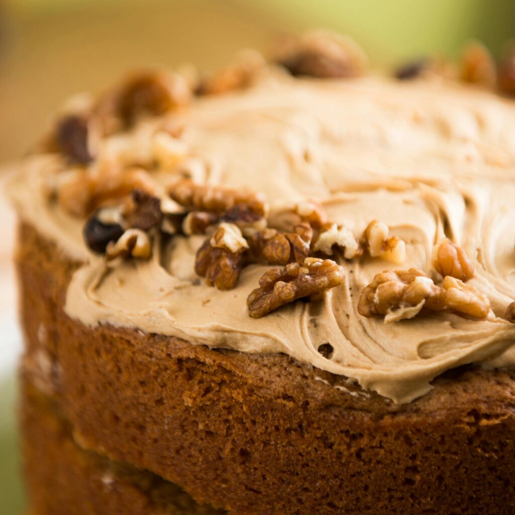 Closeup of a homemade walnut cake with creamy frosting, perfect for dessert lovers.