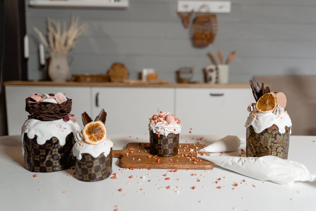Decorative cupcakes with icing and dried fruits on a modern kitchen counter, perfect for dessert inspiration.
