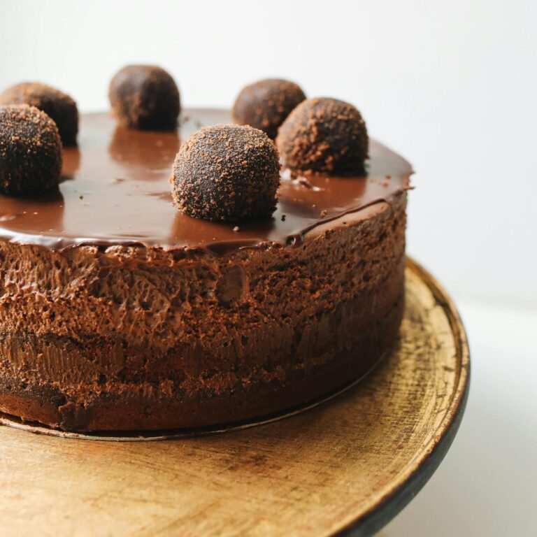 Indulge in a rich chocolate mousse cake topped with truffles, perfect for dessert lovers.
