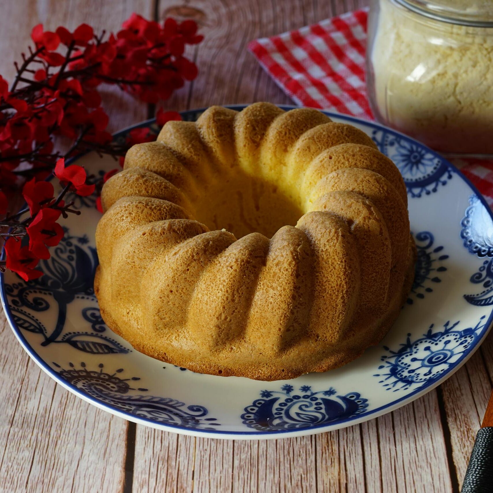 Rustic homemade bundt cake served on a ceramic plate with a wooden background.