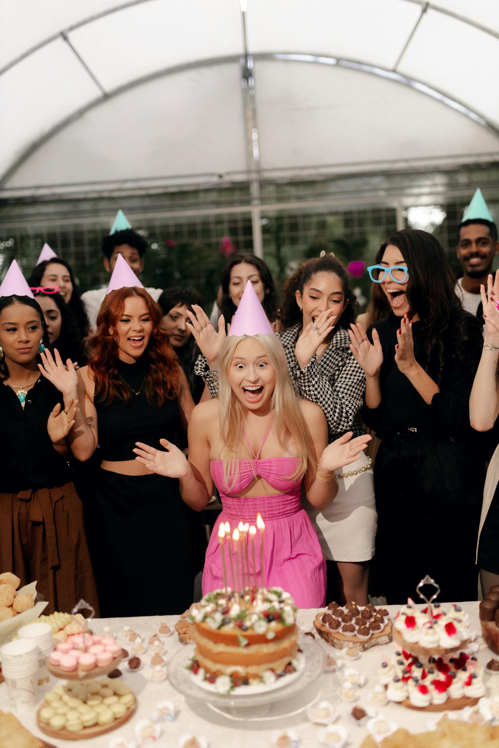 A group of friends celebrating a birthday with cake and party hats in a festive setting.