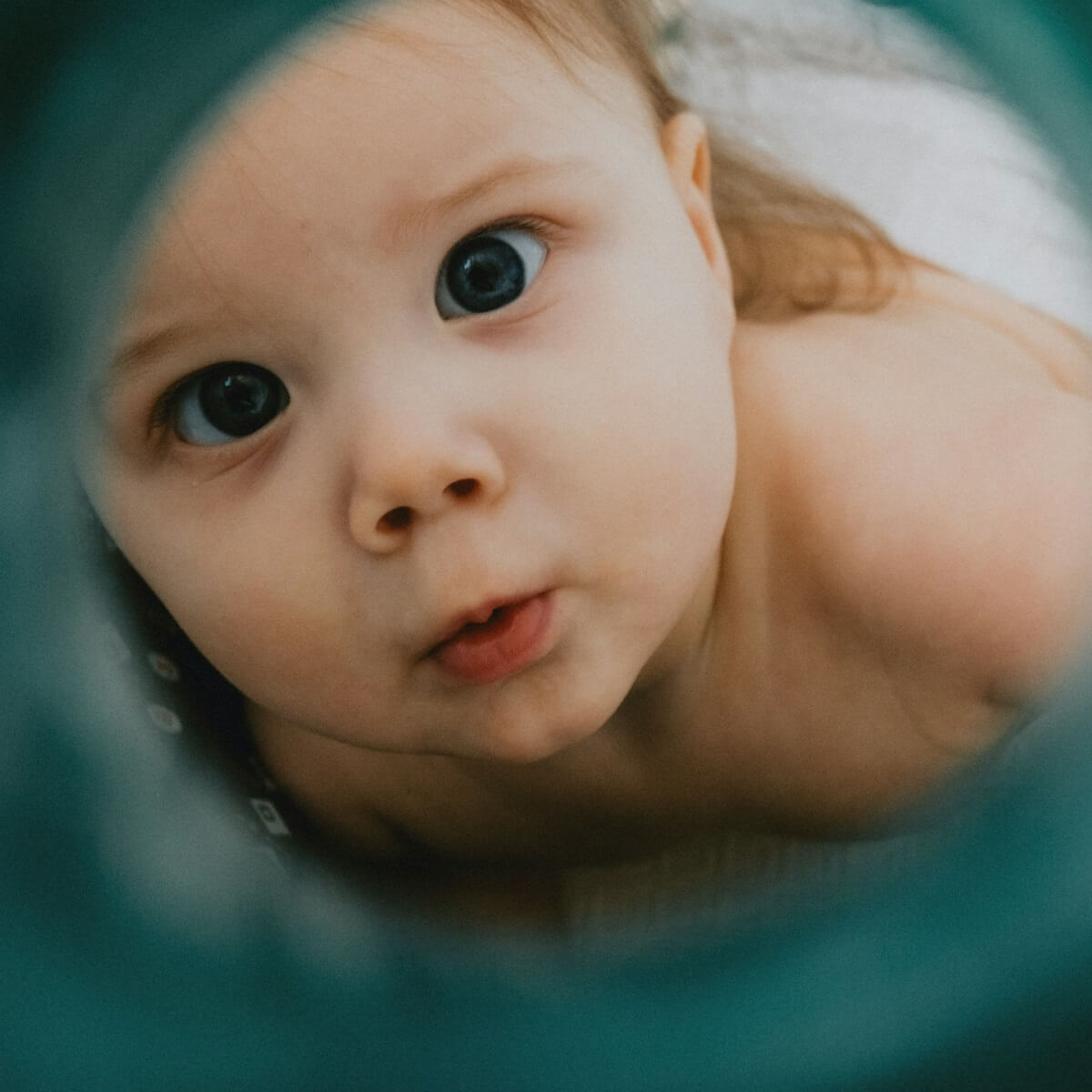 baby looking through a hole
