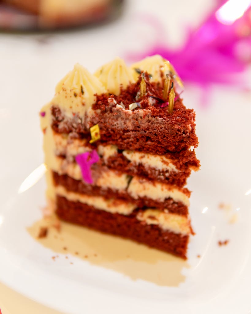Close-up of a red velvet cake slice with creamy frosting, perfect for dessert lovers.
