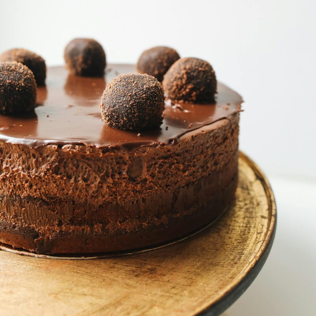 Indulge in a rich chocolate mousse cake topped with truffles, perfect for dessert lovers.